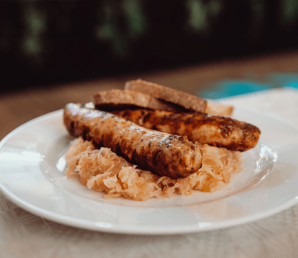 Teller mit zwei Bratwürsten, Kraut und Brot