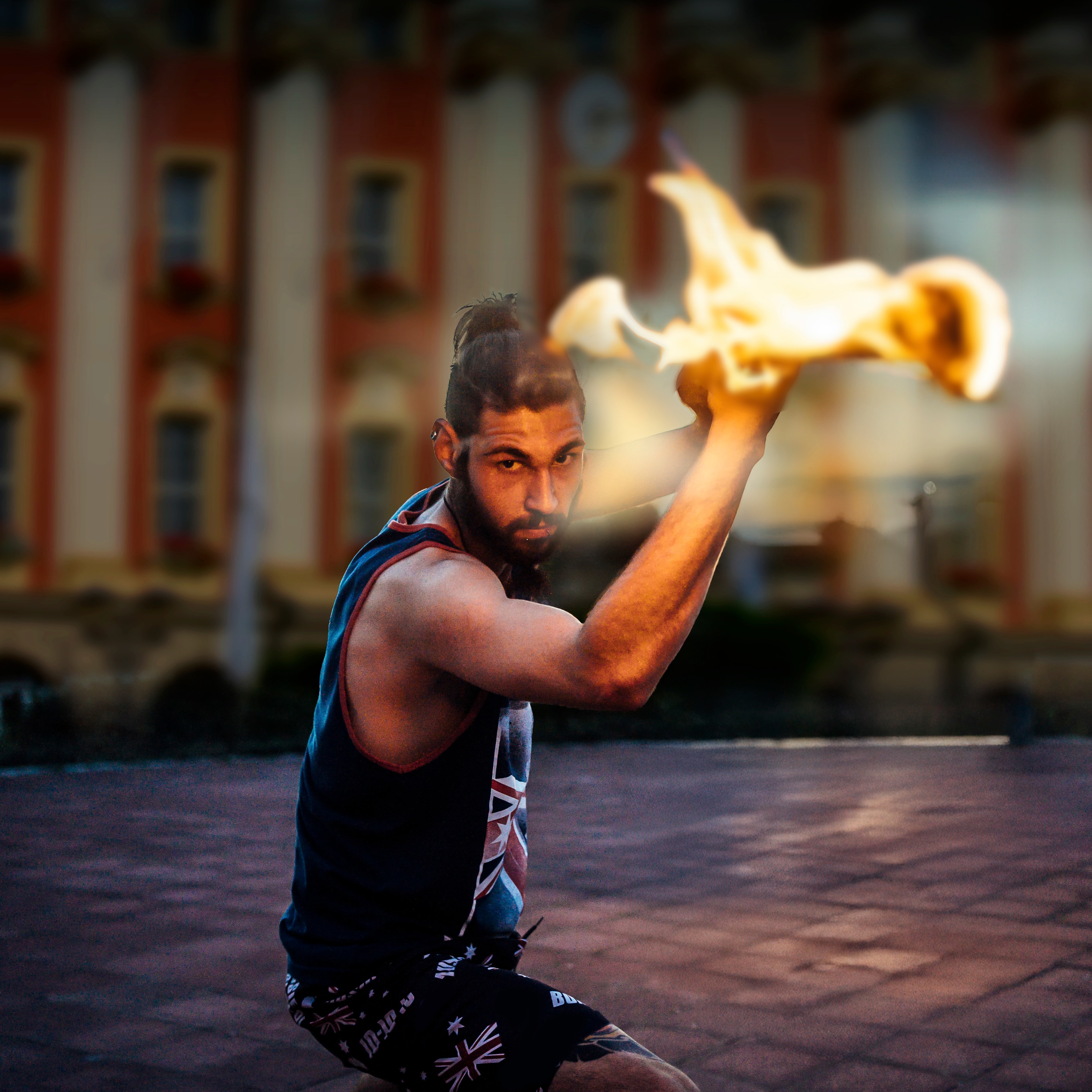 Vor dem Bad Windsheimer Rathaus führt ein bärtiger, junger, muskulöser Mann einen Feuertanz auf, er hält brennende Fackeln in den erhobenen Händen und befindet sich einer Drehbewegung mit Blick zum Fotografen