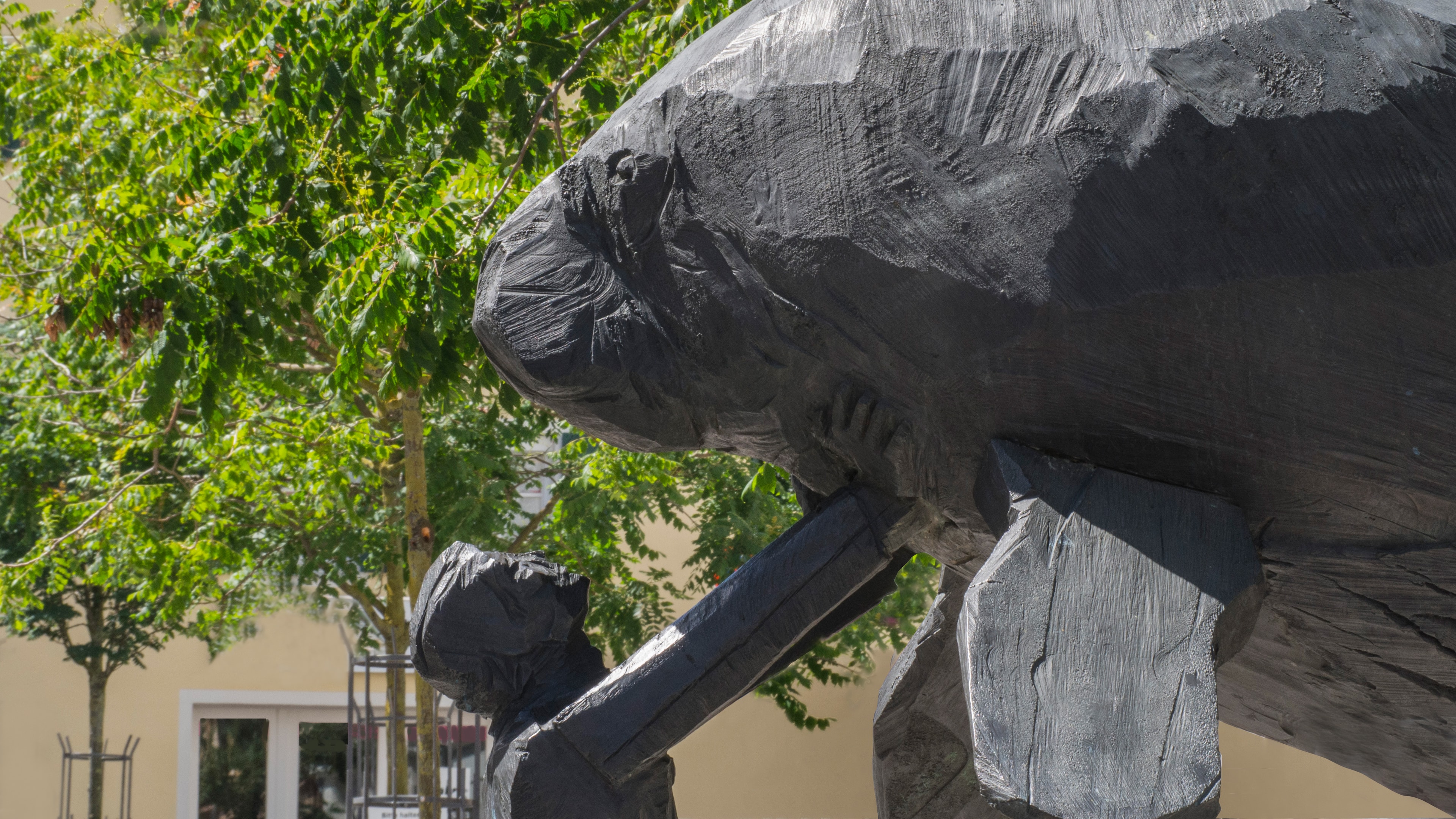 Georg-Wilhelm-Steller-Denkmal in Bad Windsheim, Bronzeguss, der junge Steller stützt mit beiden Händen eine Stellersche Seekuh nach oben, Mensch & Tier blicken sich an, keine realen Proportionen