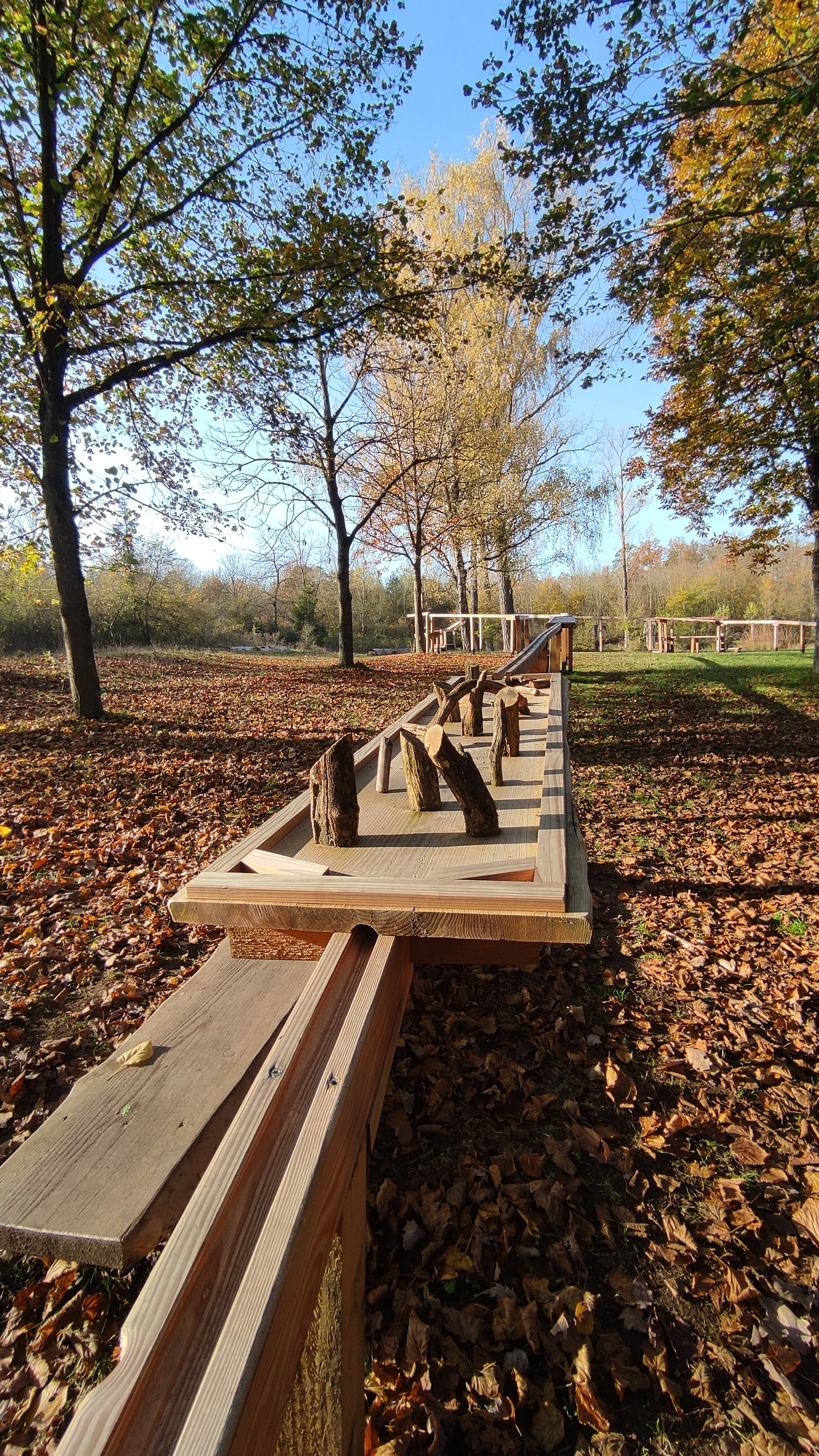 Holzkugelbahn im Hintergrund herbstliche Landschaft